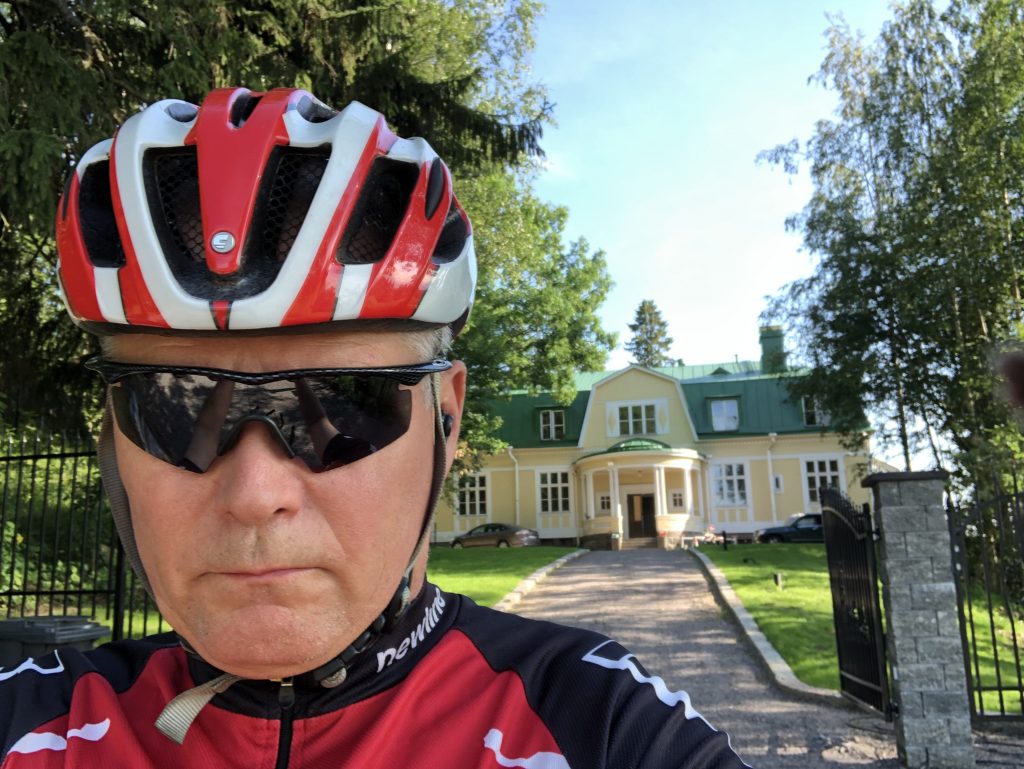 Jarmo pyöräilyvaatteissa, taustalla talo.